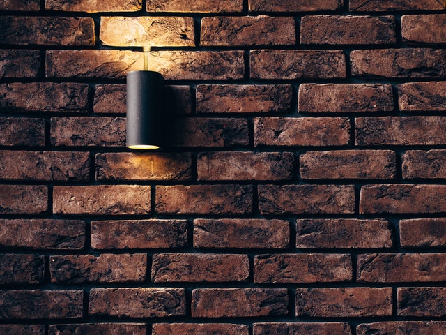 Svietiaca lampa čierne farby na tehlovej stene.jpg
